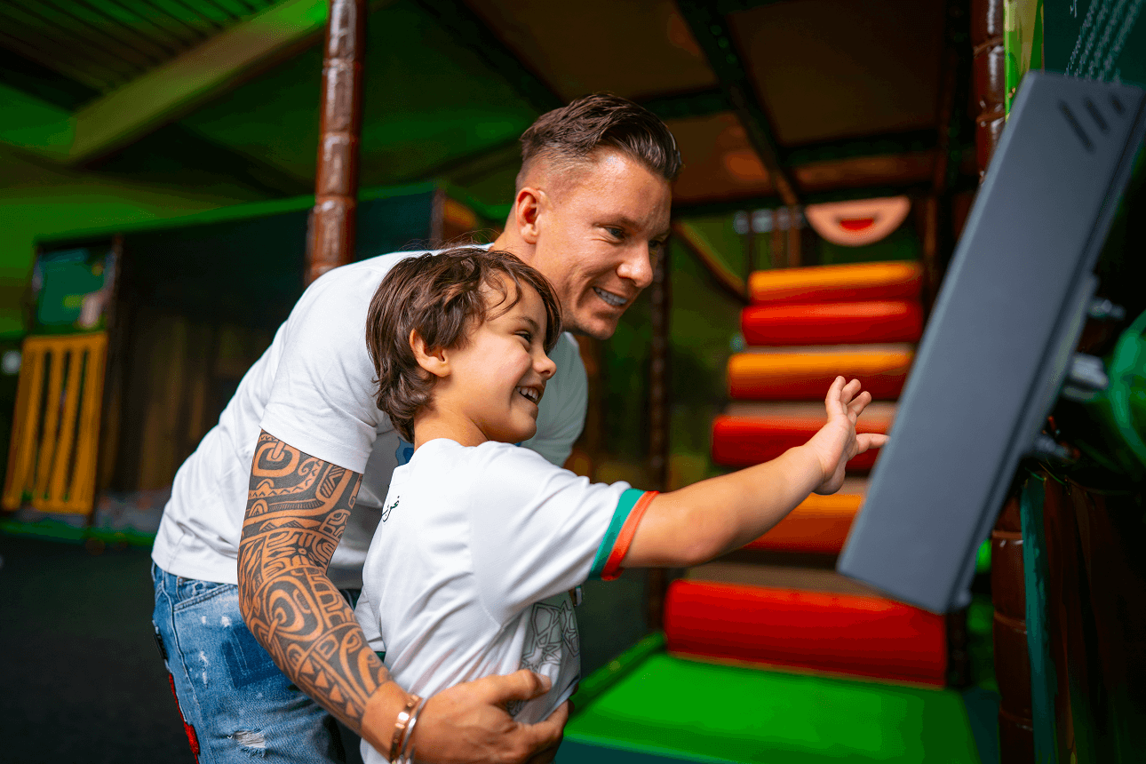 Smiling child and parent using touchscreen